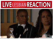 two women are standing next to each other under a live lesbian reaction banner