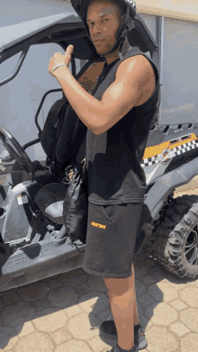 a man wearing a helmet is standing in front of a vehicle that says ' dirty ' on it