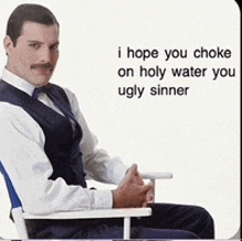 a man in a suit is sitting in a chair with a caption that says i hope you choke