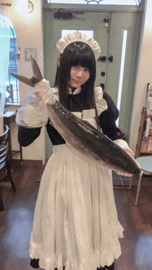 a girl in a maid costume holds a large fish