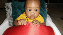 a baby is sitting in a high chair and looking at the camera