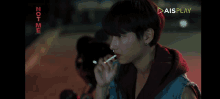 a man is smoking a cigarette in front of a screen that says not me