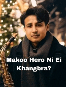 a man is holding a saxophone in front of a christmas tree and says makoo hero ni ei khangbra