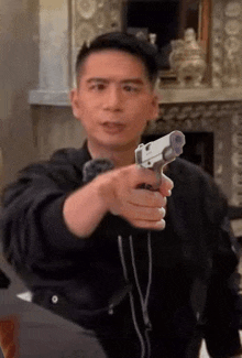 a man is holding a gun in his hand and pointing it at the camera .