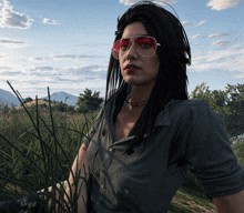 a woman wearing sunglasses and a choker is standing in a field