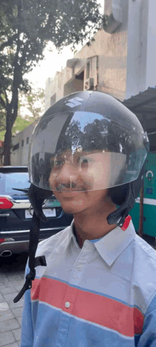 a man wearing a helmet with a clear visor looks at the camera