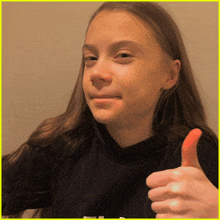 a young girl with long hair is giving a thumbs up sign