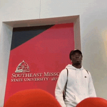 a man is standing in front of a sign that says southeast missouri state university