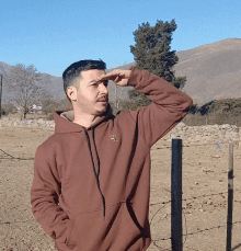 a man wearing a brown hoodie with a logo that says ' army ' on it