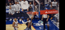 a basketball game is being played in front of a sign that says statefarm