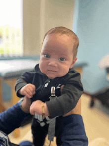 a baby with a pacifier clip on his arm