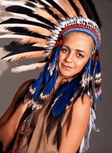 a woman is wearing a native american headdress with blue feathers