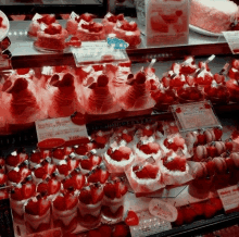 a display case full of strawberry desserts with a price tag of 180