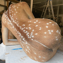 a statue of a deer is sitting on a table with a ladder behind it