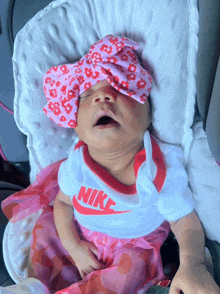 a baby wearing a nike outfit is sleeping