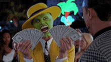 a man wearing a mask is holding a bunch of money in his hands .