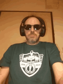 a man wearing headphones and sunglasses has a shirt that says 2011 2021