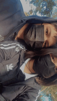 a boy and a girl wearing face masks and an adidas sweatshirt