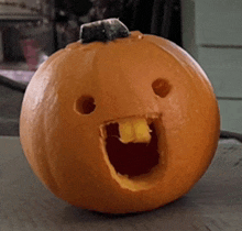 a pumpkin with a face carved into it and a mouth open