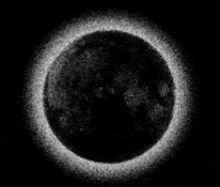 a black and white image of a full moon with a ring around it