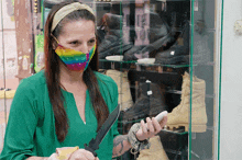 a woman wearing a mask is holding a knife in front of a display case of boots