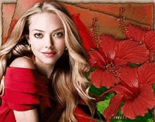 a woman in a red dress is standing in front of a red flower .