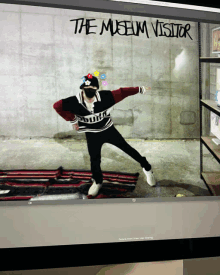 a computer screen shows a person standing in front of a wall with the words the museum visitor written on it