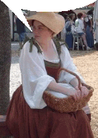 a woman in a straw hat is holding a basket in her lap .