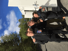 a group of young men are posing for a picture while one of them holds a pepsi can