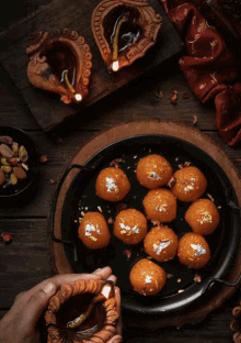 a person holding a candle in front of a plate of food with the words happy diwali written on the bottom