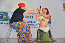 two women are dancing in front of a banner that says 5- 2017