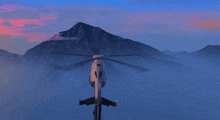 a helicopter is flying over a mountain range with a sunset in the background