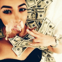 a woman is smoking a cigarette in front of a pile of money that has the number 20 on it