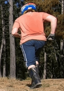 a person wearing a helmet and knee pads is running through the woods