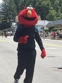 a person carrying a stuffed elmo on their back