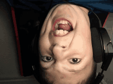 a young boy wearing headphones is upside down