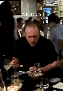 a man sitting at a table with a caption that says weco us !!