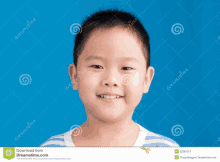 a young asian boy is smiling for the camera with a blue background