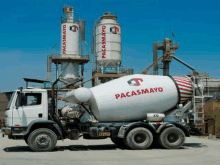 a pacasmayo concrete mixer truck is parked in front of silos