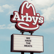 a red and white sign for arby 's says we have the meats