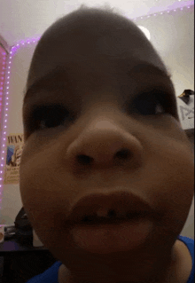 a close up of a child 's face with a poster in the background that says wanted