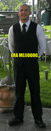 a man in a suit and tie stands in front of a sign that says era mejio000