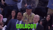 a group of people sitting in a stadium with the word golaco on the bottom