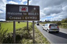 a sign that says welcome to wales croeso i gymru is on the side of a road