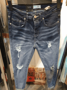 a pair of ripped blue jeans with a label that says ' denim ' on it