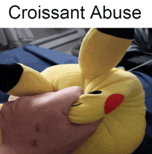 a stuffed animal with the words " croissant abuse " on the bottom