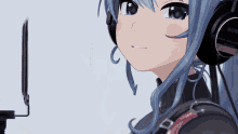 a girl wearing a pair of sony headphones stands in front of a microphone