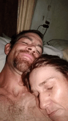 a man and a woman are laying on a bed