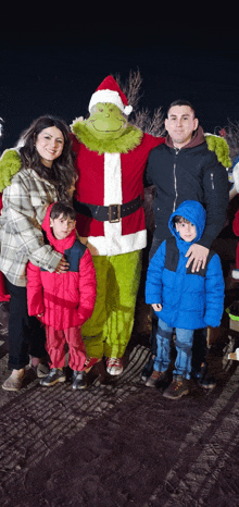 a family poses with a grinch costume