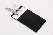 a knife and fork in a black and white napkin